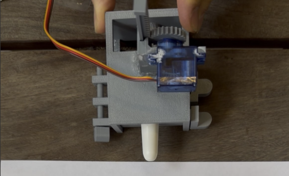 NaloPulse prototype with a servo-triggered actuator and naloxone nasal spray in a 3D-printed housing.